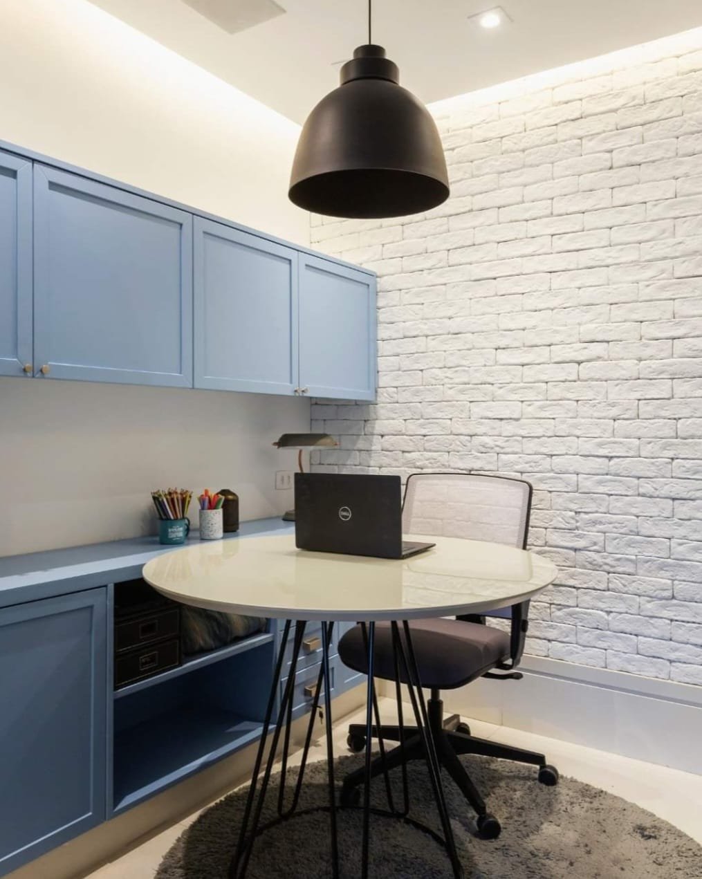 Home office azul com parede de tijolinho branco